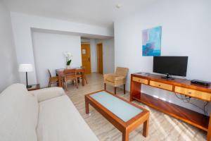- un salon avec un canapé et une télévision dans l'établissement Apartamentos Jimmy, à Nerja