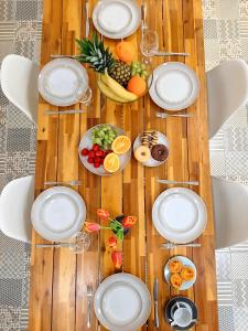 un tavolo in legno con piatti bianchi e frutta di Hola Lisbon Suites a Lisbona