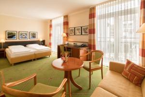ゲルゼンキルヒェンにあるHotel Buerer Hofのベッドとリビングルームが備わるホテルルームです。