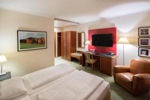 
a hotel room with a television and a bed at Hotel Buerer Hof in Gelsenkirchen
