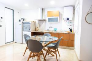 - une cuisine avec une table et des chaises dans la chambre dans l'établissement Apartamento Colon by Cadiz Time, à Cadix