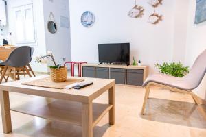 a living room with a coffee table and a tv at Apartamento Colon by Cadiz Time in Cádiz