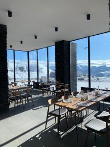 a restaurant with tables and chairs and a view of the mountains at Vista Gudauri in Gudauri