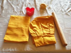 two yellow napkins and a red heart on a bed at Relais Il Mulino in Corigliano Calabro