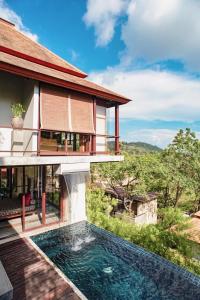 une villa avec une piscine en face d'une maison dans l'établissement Villa Zolitude Resort & Spa - SHA Extra Plus, à Chalong