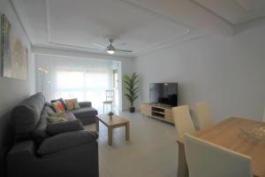 a living room with a couch and a tv and a table at CasaTuris Rambla Méndez Núñez en el corazón de Alicante A109 in Alicante