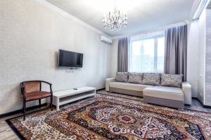 un soggiorno con divano e TV di ЖК Дипломат a Astana