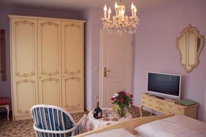 Hotel Garni Regina في غوسوينستين: غرفة معيشة مع طاولة طعام وتلفزيون