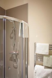 a shower in a bathroom with towels on a wall at Toothbrush Apartments - Ipswich Central East in Ipswich +33 photos