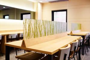 a classroom with tables and chairs with grass on the wall at Super Hotel Namba Nipponbashi in Osaka