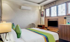 a bedroom with a large bed and a flat screen tv at Hotel Sun Grand in Dehradun