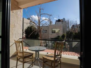 a balcony with a table and two chairs and a window at La Locanda Boutique Hotel in Amman