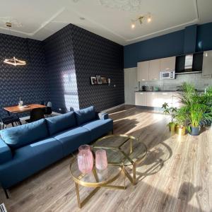 a living room with a blue couch and a table at Apartement City Centre with roof terrace and parking with additional costs in The Hague