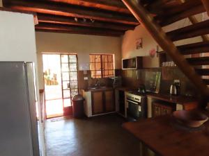 a kitchen with wooden ceilings and an open door at Bush and Gables House in Marloth Park