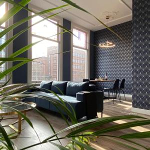 een woonkamer met een blauwe bank en een tafel bij Apartement City Centre with roof terrace and parking with additional costs in Den Haag