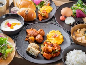 a table with plates of food and bowls of food at Super Hotel Shinbashi-Karasumoriguchi in Tokyo