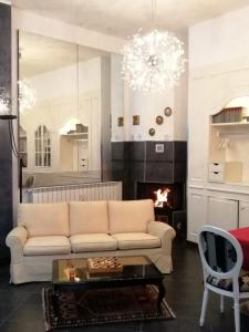 a living room with a white couch and a fireplace at Al 20 Guest House Fiera Milano - Certosa - San Siro in Milan