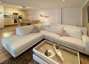 - un salon avec un canapé blanc et une table dans l'établissement Wilsmann Apartmentvermietung, à Hövelhof