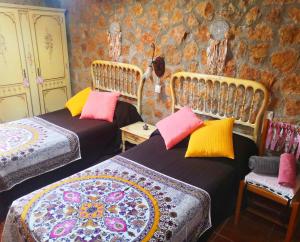 a room with two beds with colorful pillows at Casa Conesa II in Tronchón +44 photos