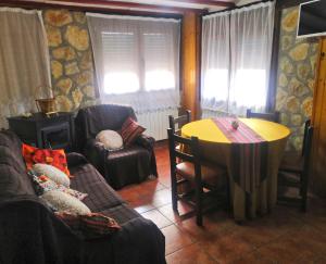Casa Conesa II في Tronchón: غرفة معيشة مع أريكة وطاولة وكراسي