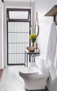 een witte badkamer met een toilet en een wastafel bij Tama House in Tây Ninh