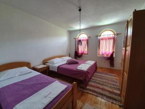 a bedroom with two beds and two windows at Villa Velagic in Blagaj +37 photos