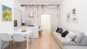biały salon z kanapą i stołem w obiekcie Italianway - Garigliano 8 w Mediolanie
