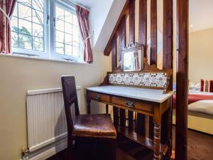 a room with a wooden desk and a bed at Anne Boleyn in Winchcombe
