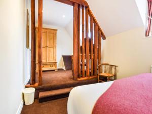 a bedroom with a bed and a wooden door at Anne Boleyn in Winchcombe +18 photos