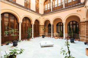 un grande edificio con cortile con piante in vaso di The Old Print House - Space Maison Apartments a Siviglia