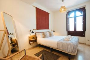 ein kleines Schlafzimmer mit einem Bett und einem Fenster in der Unterkunft The Old Print House - Space Maison Apartments in Sevilla