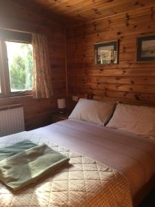 a bedroom with a bed in a log cabin at Chalet in Tyndrum