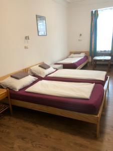 a group of three beds in a room at Hotel Pension Schmellergarten in Munich