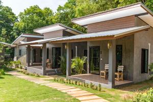 a home with a patio and grass at Hanoii House in Ko Mak