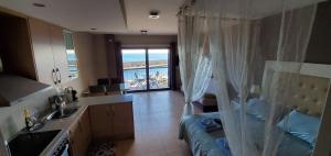 una cocina con fregadero y una habitación con ventana en Bella vista, en L'Ametlla de Mar