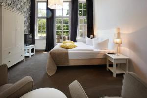 - une chambre avec un lit, une télévision et des fenêtres dans l'établissement Gut Vorbeck, à Gneven