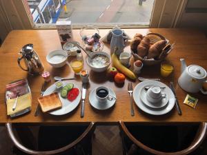 a wooden table with breakfast foods on it at Hotel Museumzicht in Amsterdam
