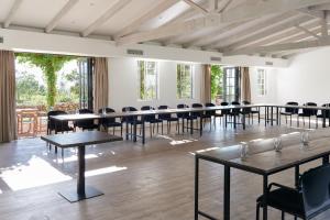 フランシュホークにあるBoschendal Farm Estateのテーブルと椅子、窓が備わる広い客室です。