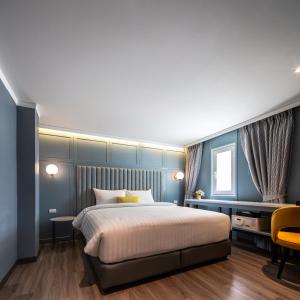 a bedroom with a large bed with blue walls at The Mulberry Bangkok Khaosan Road in Bangkok