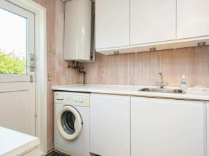 uma cozinha com uma máquina de lavar roupa e um lavatório em 6 person holiday home in B rkop em Børkop