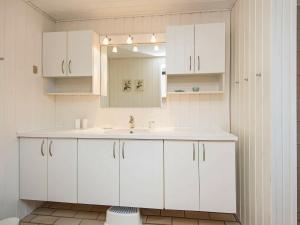 uma casa de banho branca com um lavatório e um espelho em 6 person holiday home in B rkop em Børkop
