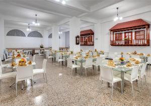 ein Esszimmer mit Tischen und weißen Stühlen in der Unterkunft Hotel Dorado Plaza Centro Histórico in Cartagena de Indias