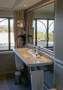 bagno con lavandino e grande specchio di Le Jas de Gordes a Gordes