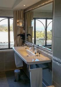 La salle de bains est pourvue d'un lavabo et d'un grand miroir. dans l'établissement Le Jas de Gordes, à Gordes