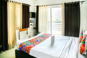 a bedroom with a large bed with a window at FabHotel Eleanora Inn New Town in Kolkata