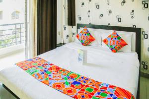 een bed met een kleurrijk dekbed en 2 kussens bij FabHotel Eleanora Inn New Town in Calcutta
