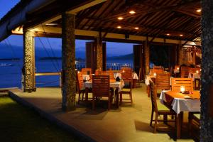 a restaurant with tables and chairs and a view of the ocean at Cocotinos Sekotong Lombok in Sekotong