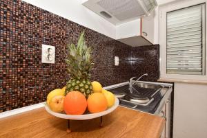 un bol de fruta en una barra en la cocina en Apartments Makarska Gudelj Cvitan, en Makarska