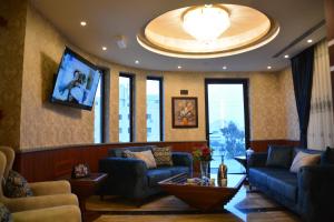sala de estar con 2 sofás y TV en سما عمان للشقق الفندقية Sama Amman Hotel Apartments en Amán