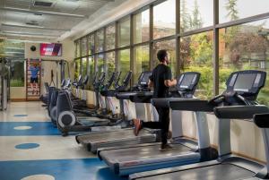 a man running on a treadmill in a gym at Boulevard Suites Ferrat in Santiago